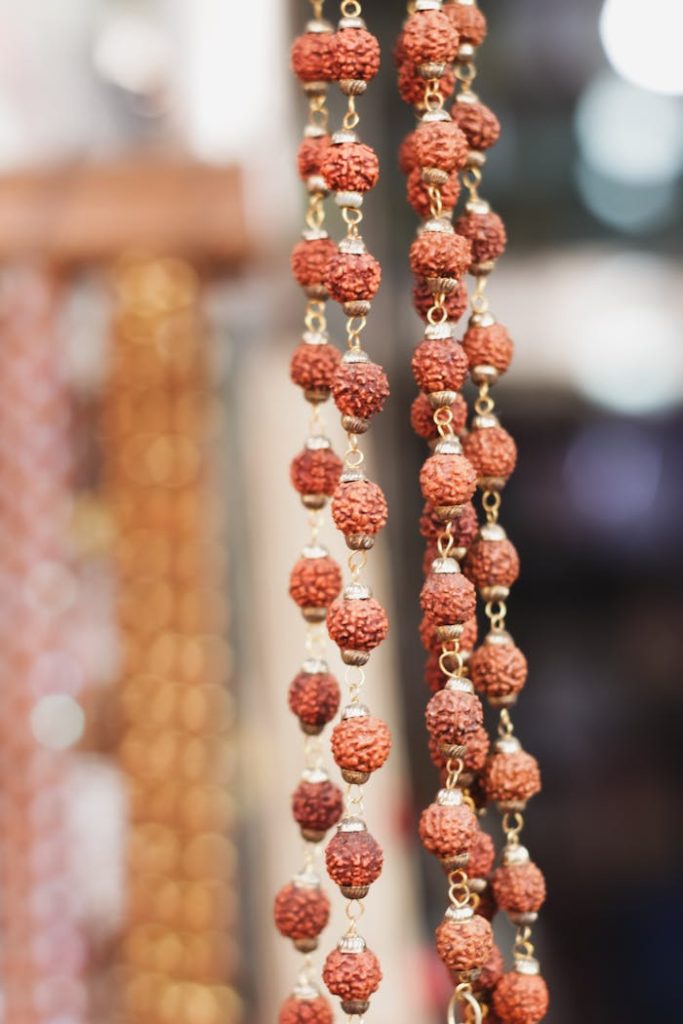 Close-up of traditional Rudraksha beads hanging in a vibrant Varanasi street market.